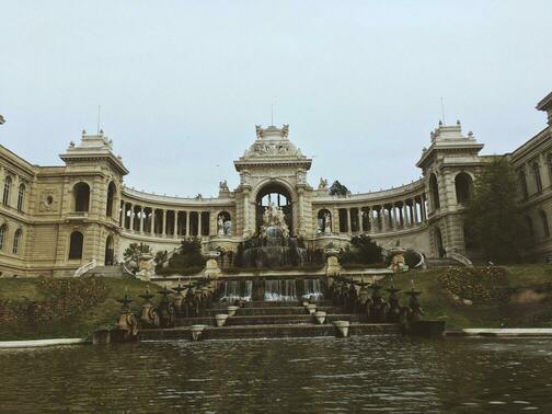 une structure en pierre ornée, avec une fontaine devant.