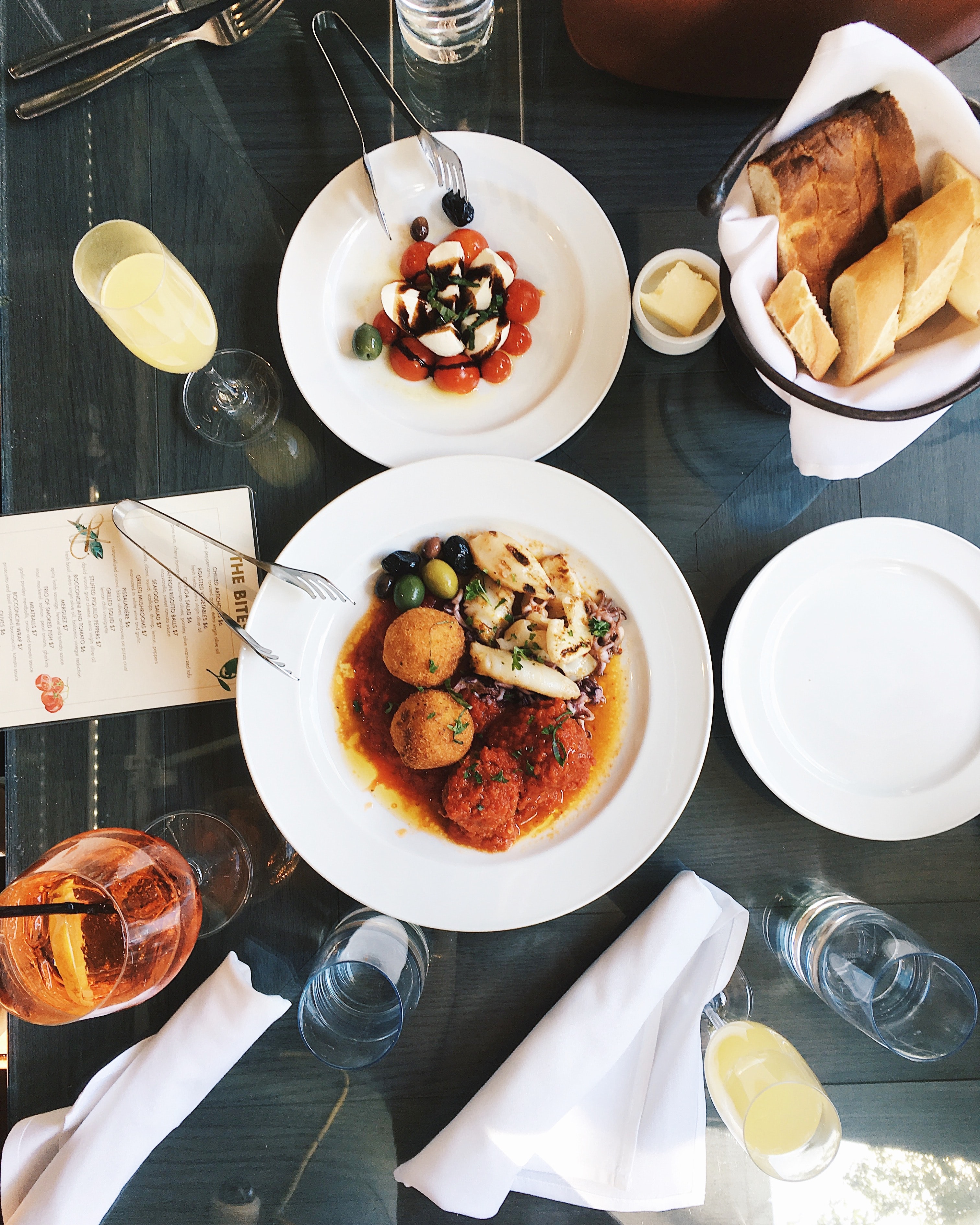 birdseye view of a plate of meatballs and tomato sauce, olives, fish and squid